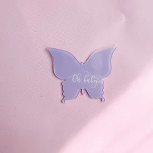 Detail de decoration de gateau en acrylique papillon mauve pour fete de bebe.
