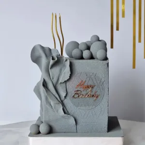 Minimalist grey birthday cake decoration with acrylic happy birthday sign and gold candles.
