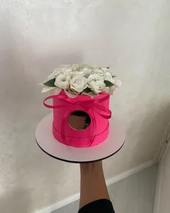 Pink round flower gift box with white roses and acrylic happy birthday cake board decor for party.