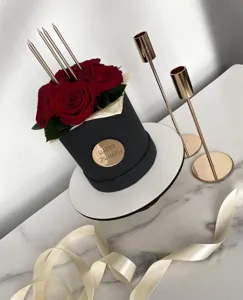 Detailed view of black birthday flower box with red roses, gold candles and happy birthday tag.