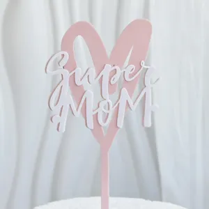Detalle de cake topper super mom acrílico, diseño de corazón rosa para día de la madre.