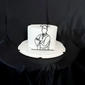 Close up of a black acrylic graduation cake topper featuring a graduate silhouette line art.