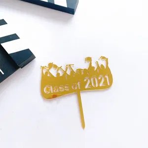 Primer plano del adorno de tarta de graduación de acrílico dorado con detalles.