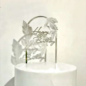 Silberner Acryl Bogen Kuchendeckel Detailansicht mit filigranen Blättern und Aufschrift.