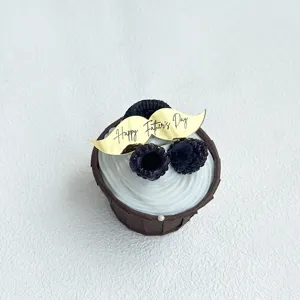 Primo piano dettagliato di topper per cupcake in acrilico dorato con baffi e testo festa del papà.