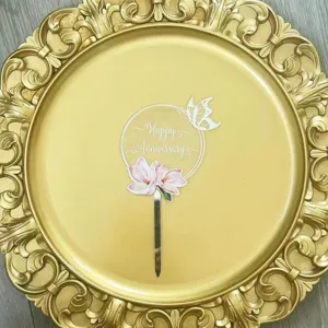 Detailed view of clear acrylic anniversary cake topper with pink magnolia and butterfly design.
