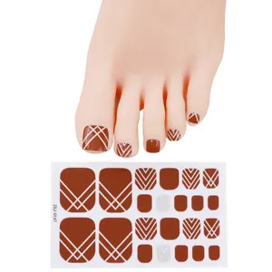 Bruine geometrische teennagelstickers met voetmodel, zomerse nail art folies voor vrouwen.