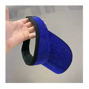 Vista de cerca del sombrero con visera de diamantes de imitación azules brillantes.