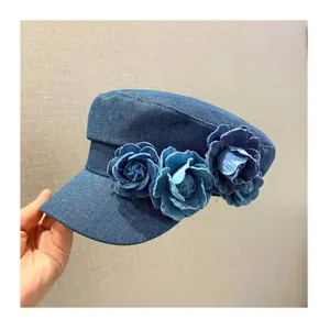 Detailed view of vintage denim flat cap featuring handmade fabric flower decorations.