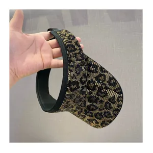Detalle visera sol leopardo estrás, gorra vacua brillante mujer verano exterior.