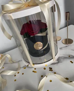 Transparent acrylic cylinder gift box with red roses and ribbon, perfect for birthday decor.