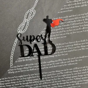 Vista dettagliata del topper per torta in acrilico nero con Super Dad e silhouette.