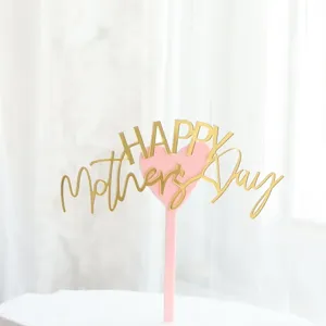 Primer plano detallado de la decoración de pastel en acrílico dorado y rosa Mother's Day.