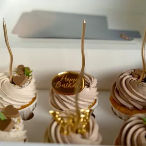 Close up of gold acrylic happy birthday cake topper set with candles for party decor.