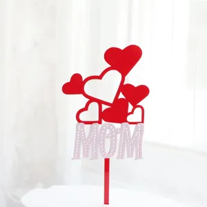 Detalle de cake topper acrílico para el Día de la Madre con corazones rojos y MOM.