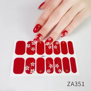 Detailed view of red floral nail wraps featuring white flowers and gold accents.
