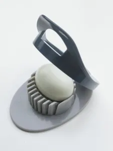 Vue détaillée de l'outil de découpe d'œufs en plastique gris pour œufs durs.