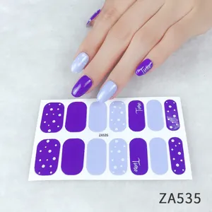 Close-up detail of purple and light blue polka dot nail wrap stickers with elegant manicure.