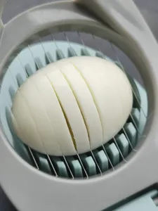 Détail du coupe-œufs en acier inoxydable montrant les fils précis pour les œufs et les fruits.