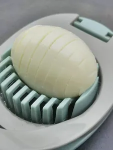 Détail de coupe-œufs en acier inoxydable montrant des tranches soignées d'un œuf dur.