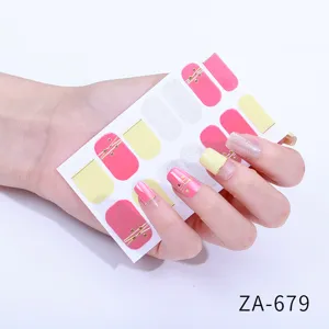 Close-up detail of colorful nail art stickers with pink, yellow and delicate gold line accents.