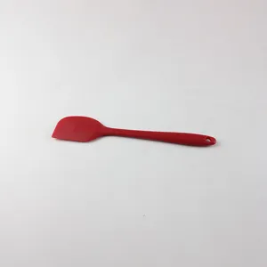 Red silicone spatula detail, flexible baking scraper tool for kitchen and cake cream prep.