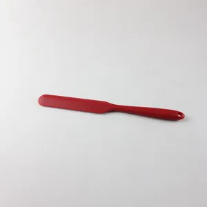 Red silicone spatula detail view, flexible scraping head with hanging hole for easy baking storage.