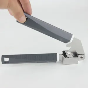 Detail view of the stainless steel garlic press with ergonomic grey handle and press mechanism.