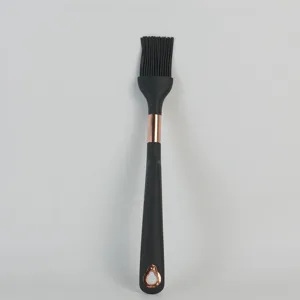 Black silicone basting brush with rose gold accent, durable kitchen baking tool detail view.