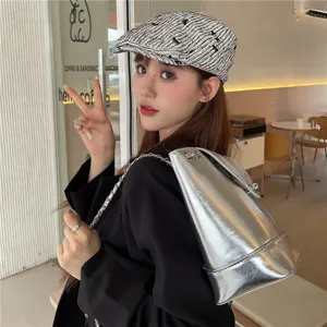 Vue détaillée d'un béret élégant et décontracté porté par un modèle dans un café, style mode.