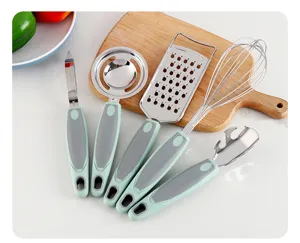 Stainless steel kitchen gadget set with peeler grater whisk and egg separator for home use.
