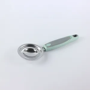 Separador de claras de huevo de acero inoxidable con mango ergonómico verde y gris.