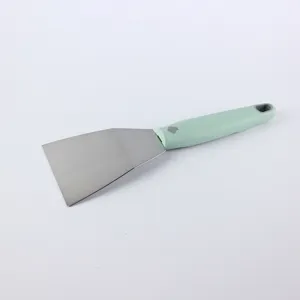 Primer plano detallado de la espátula de acero inoxidable con mango verde para cocina.