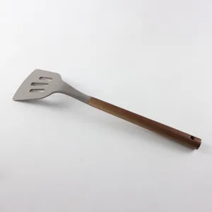 Vue détaillée spatule ajourée en silicone avec manche en bois, ustensile cuisine gros plan