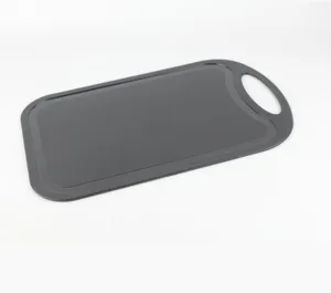 Plastic cutting board with handle hole, anti-slip kitchen tool for fruit and vegetable prep.