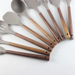 Détails en gros plan d'ustensiles de cuisine en silicone avec des poignées en bois.
