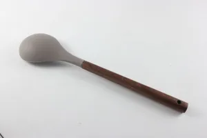 Détail de louche à soupe en silicone avec manche en bois, ustensile de cuisine résistant.