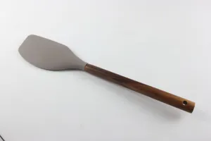 Vue détaillée de la tête de spatule en silicone avec manche en bois sombre et trou de suspension.