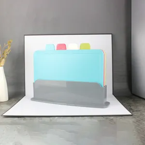 Detailed close-up of plastic cutting board set with multi-color boards and grey storage stand.