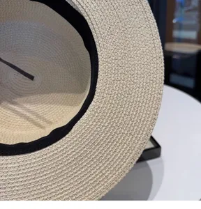 Detalle en primer plano de sombrero de paja de mujer, textura tejida natural y fina.