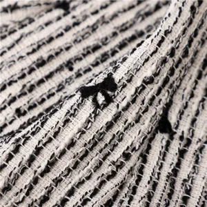 Gros plan des détails du tissu tweed noir et blanc avec un joli nœud pour chapeau.