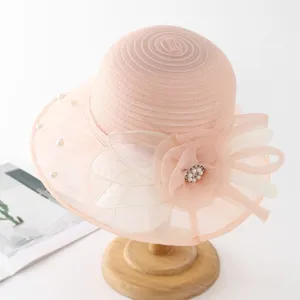 Pink organza sun hat with pearl and flower detail, elegant lace bucket hat for summer beach.