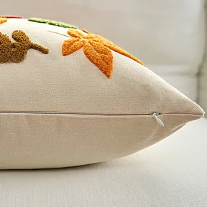 Close-up of beige autumn leaf embroidered throw pillow cover detail with hidden zipper.