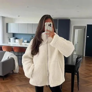 Cozy cream sherpa fleece jacket detail, high collar design, warm winter outerwear style.