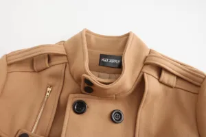 Close-up detail of men's wool trench coat collar, epaulets, and branded collar label.