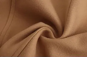Close-up detail shot of men's wool coat fabric, showing soft camel fleece and neat stitching.
