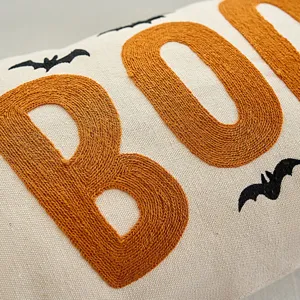 Close-up detail of Halloween embroidered BOO cushion cover with bats pattern texture fabric.