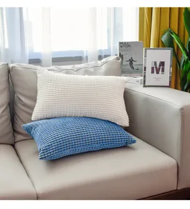 Detail view of modern minimalist corduroy waffle pillow covers on a sleek living room sofa.