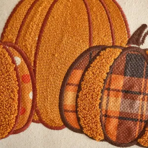 Primo piano della federa per cuscino ricamata di zucca, design a quadri per divano.