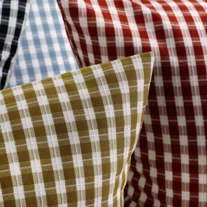 Primo piano dettagliato di federe per cuscini a quadri colorati in resistente poliestere.